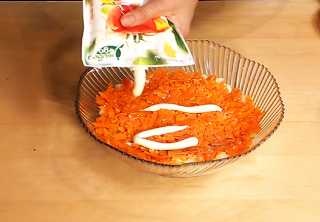 Подготовленную морковь равномерно распределяем поверх картофеля, слегка присаливаем, добавляем майонез и равномерно его распределяем по поверхности.